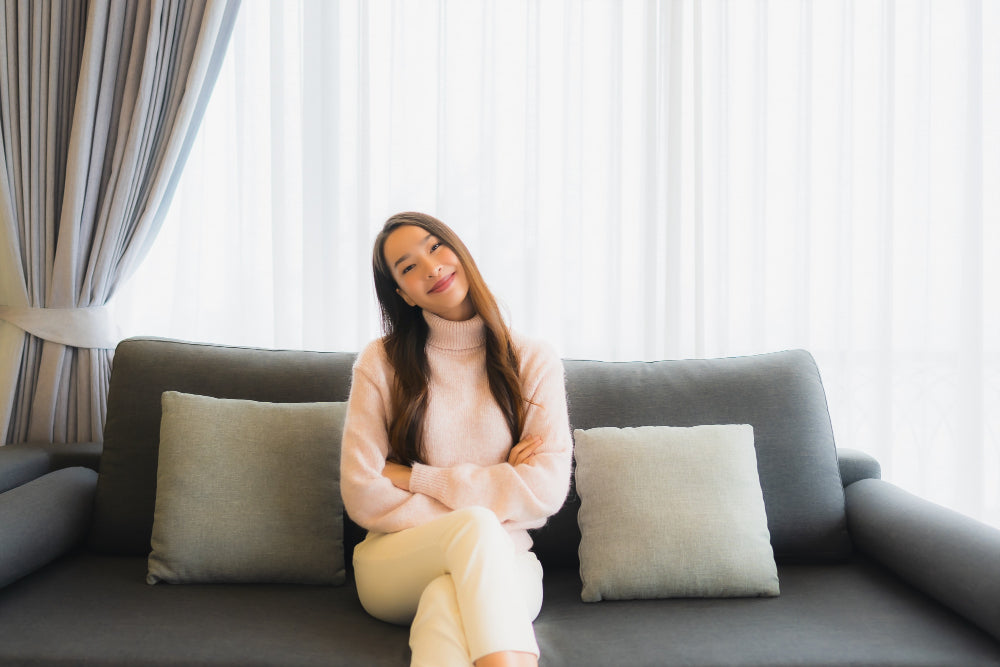 Compact sofa settee under a window in a modern apartment, showing whats a settee and how it fits small spaces beautifully.