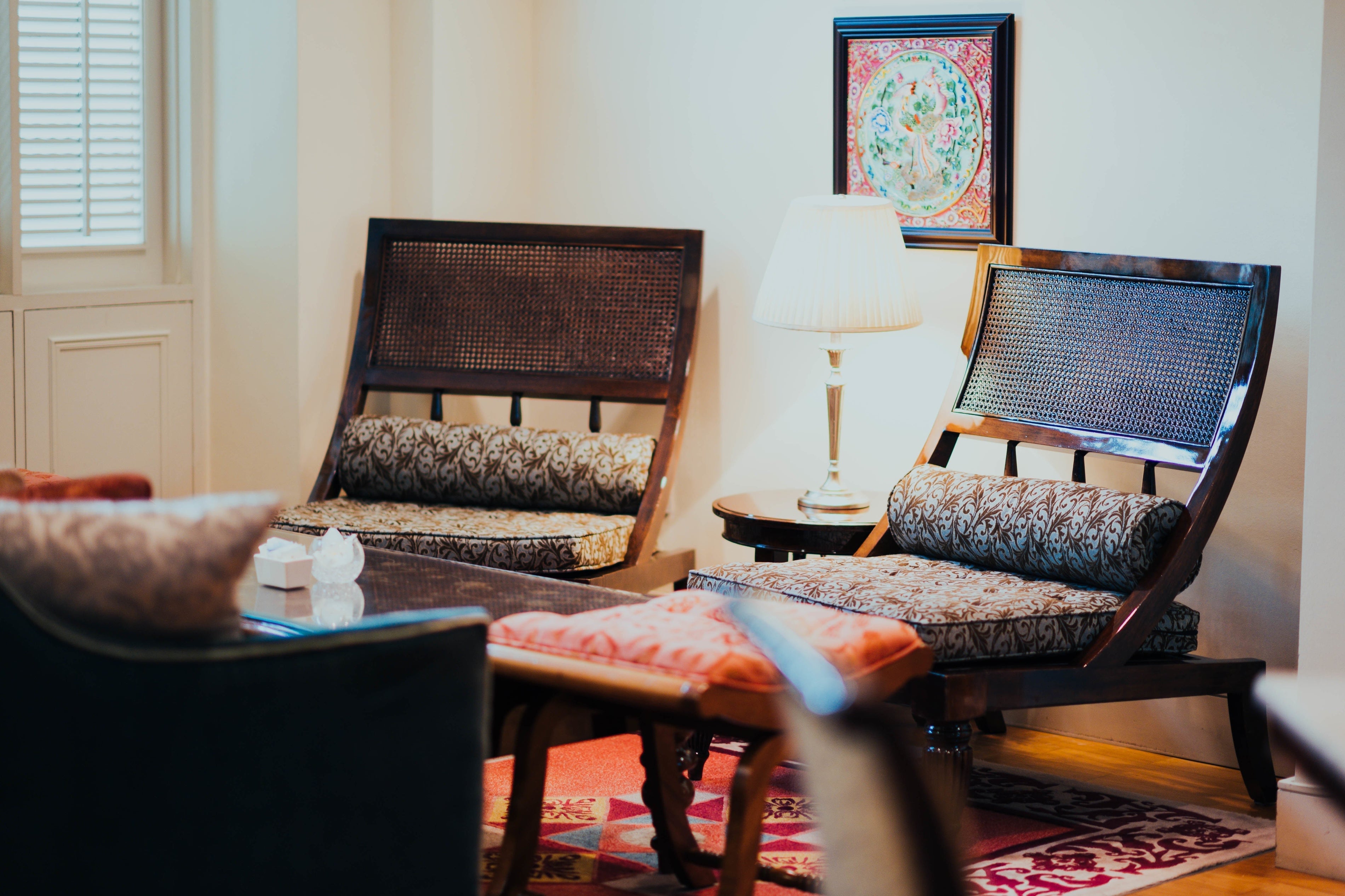 Traditional wooden chairs with matching ottoman footrests in classic living room setup