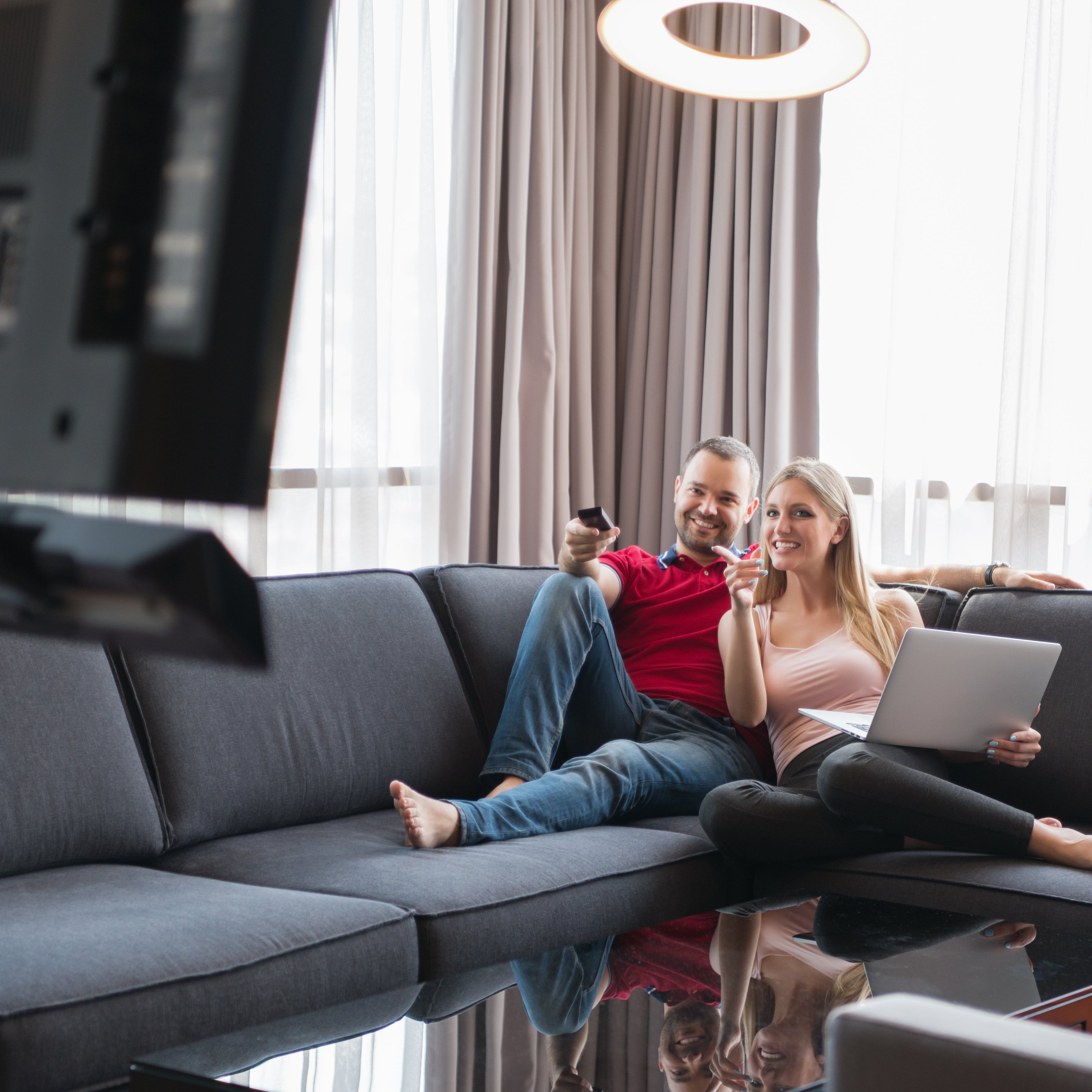 A young couple enjoys a TV show