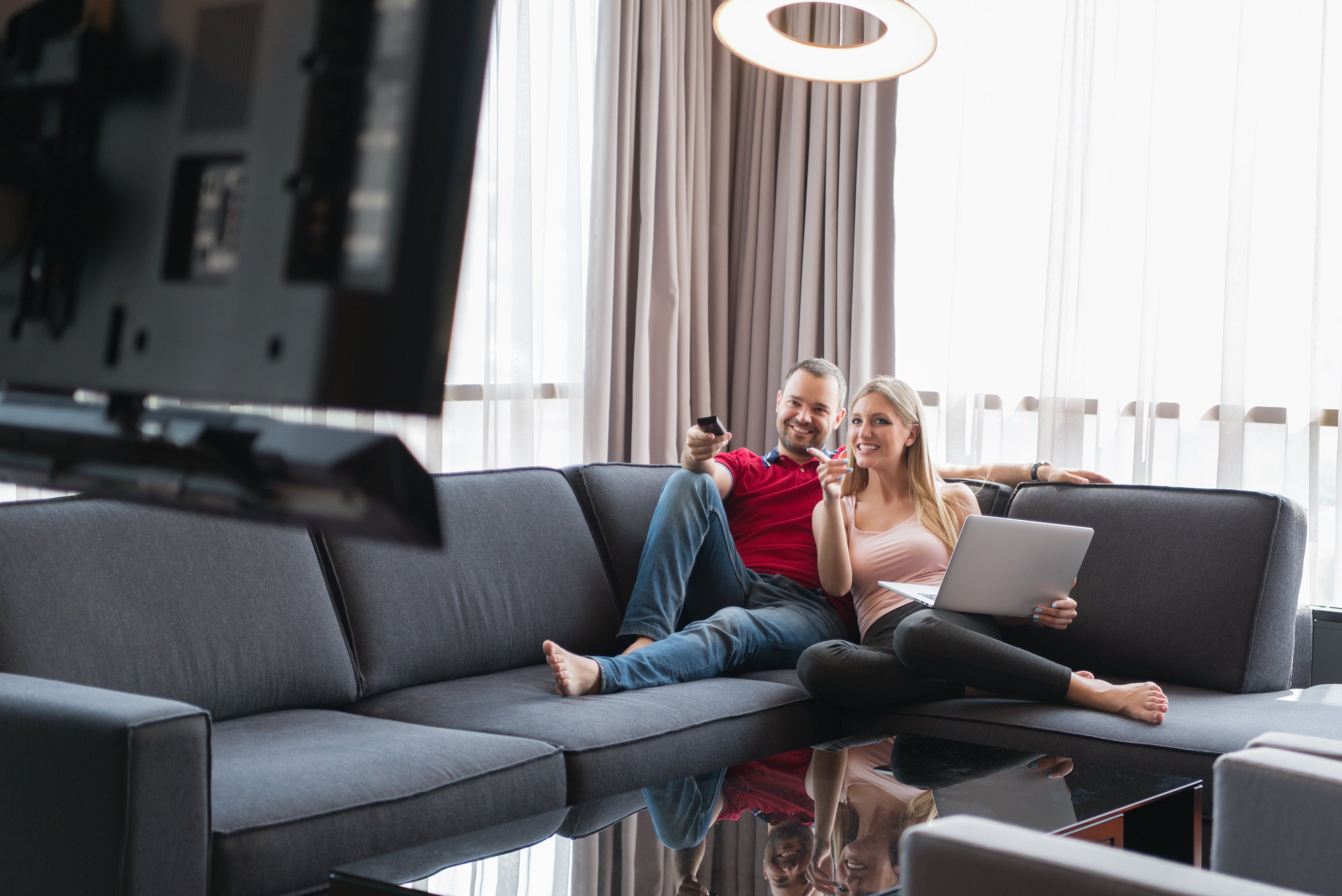 A young couple enjoys a TV show